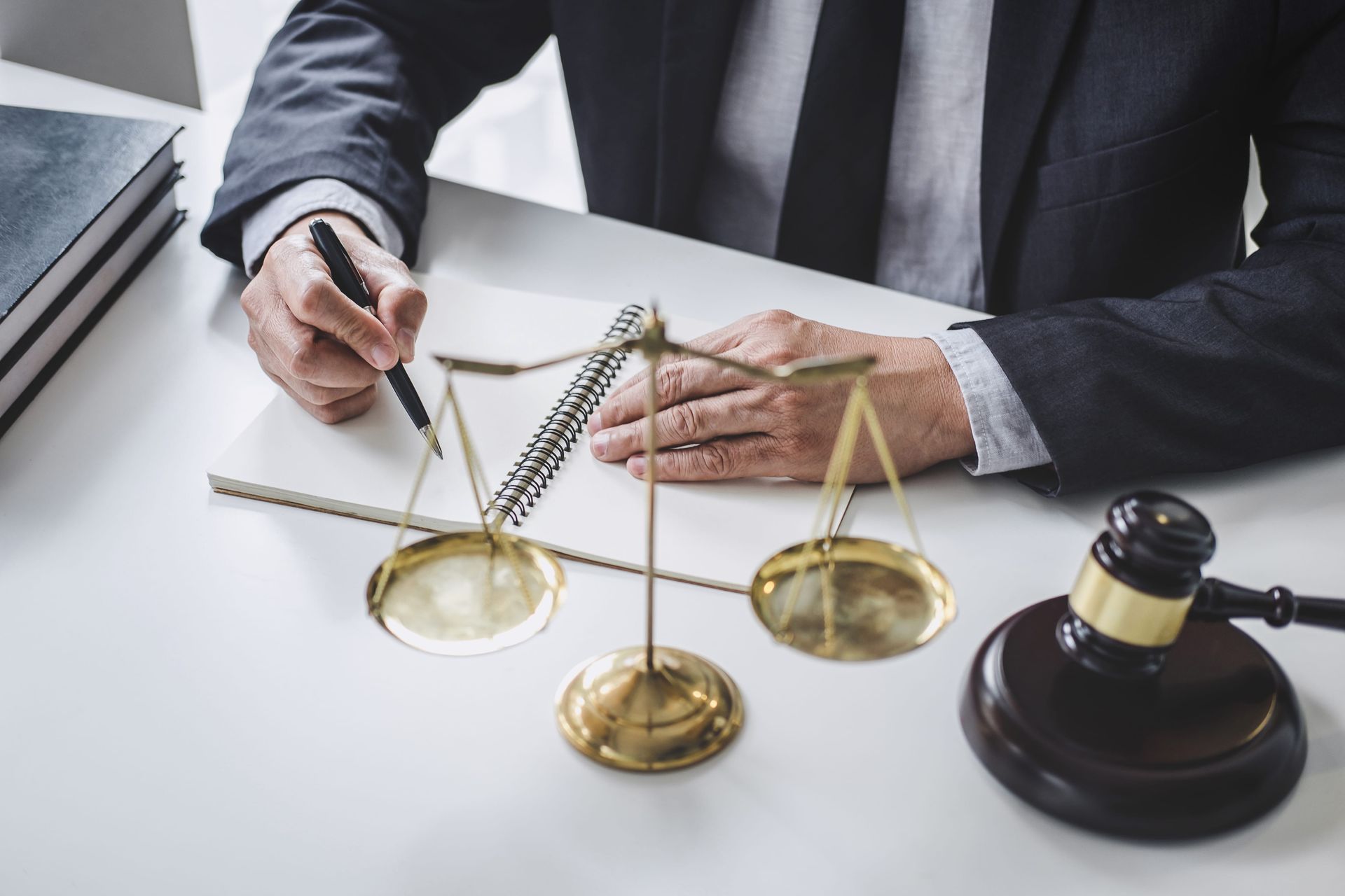 Lawyer reviewing documents beside scales of justice and a judge’s gavel on a desk