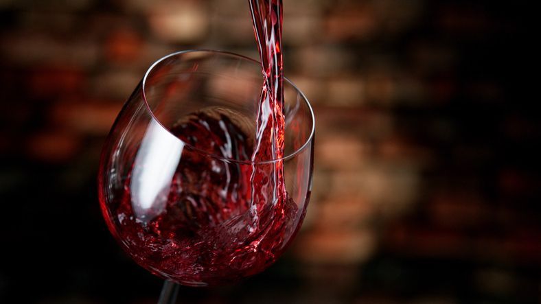 Freeze motion of red wine pouring into glass