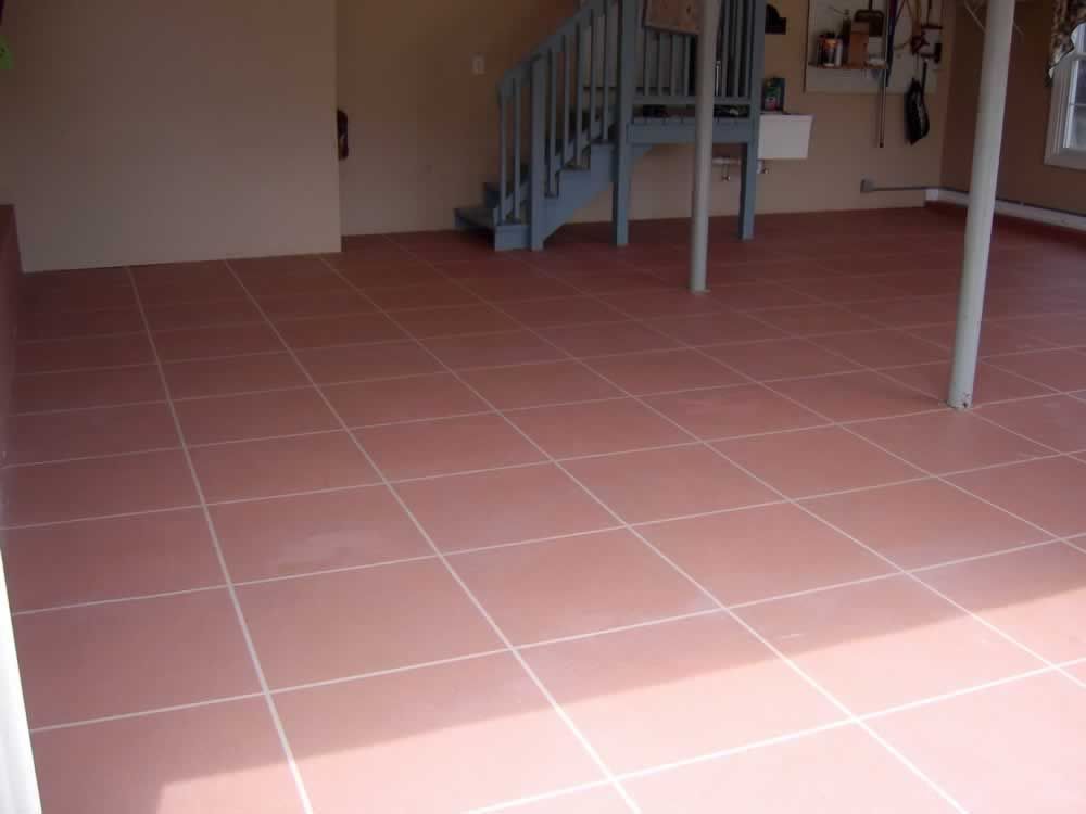 Indoor room with pink tiled floor, staircase, and white table legs in the background