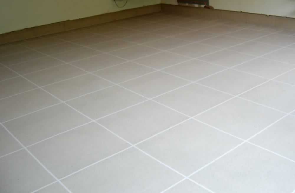 Empty room with light beige tiled floor and green walls