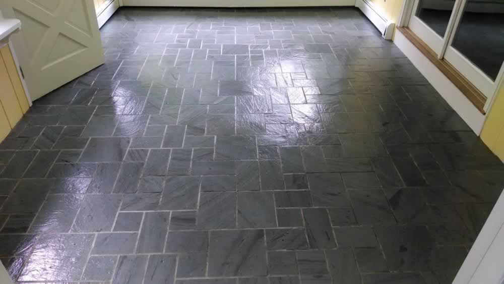 Dark gray tiled hallway floor with light-colored walls and doorway trim