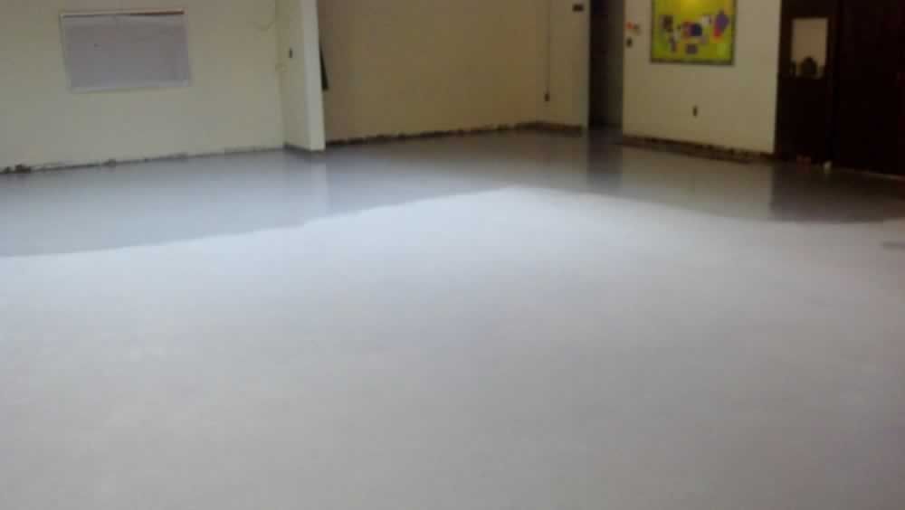 Empty room with white floor, beige doors, and a small wall poster.