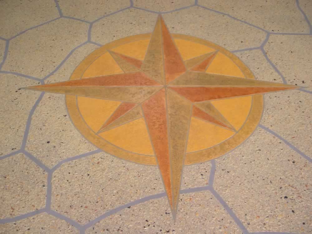 Orange and red compass rose mosaic on a light stone floor, centered in the frame