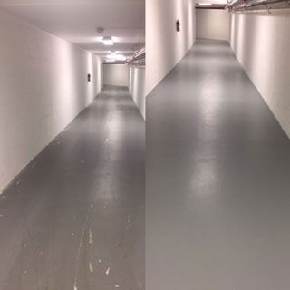 Empty gray hallway with white walls and ceiling lights, viewed from an angle