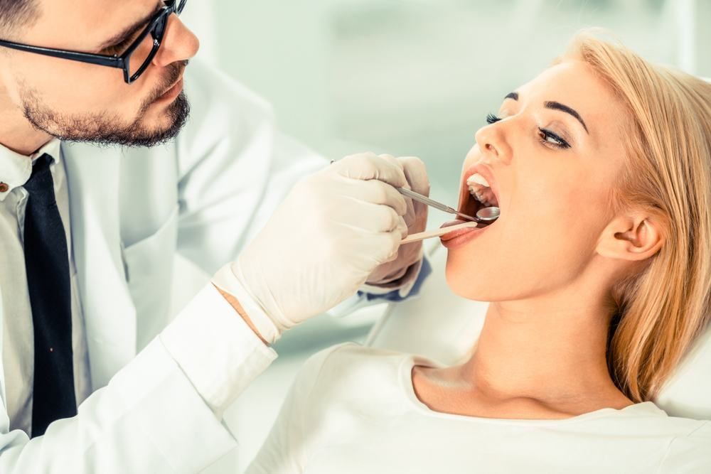 A Woman Is Having Her Teeth Examined By A Dentist — Dental Care Smithfield In Trinity Beach, QLD