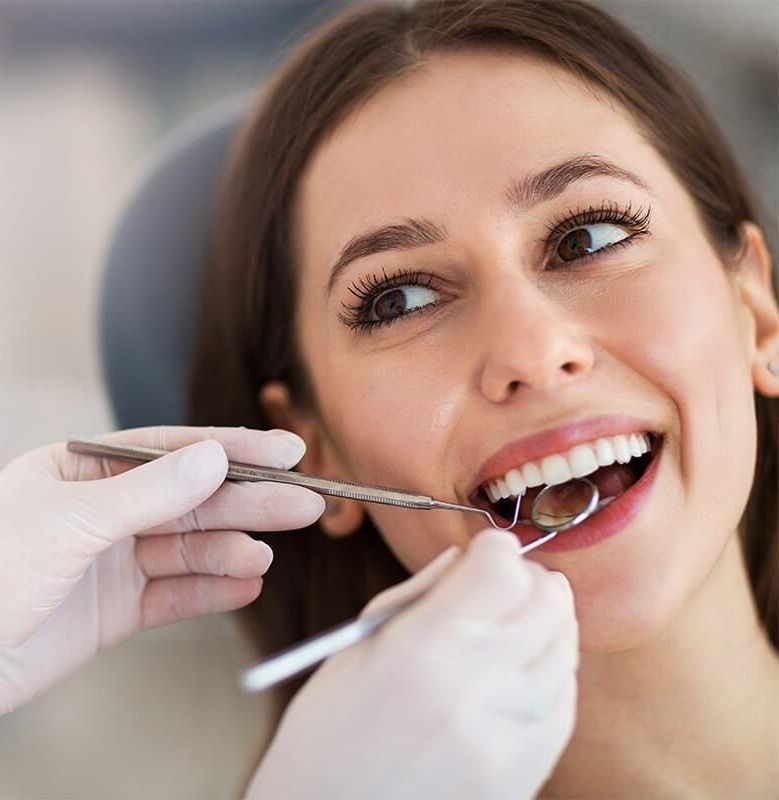 A Woman Is Getting Her Teeth Examined By A Dentist — Dental Care Smithfield In Smithfield, QLD