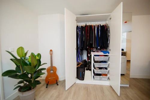 A Guitar is Sitting in Front of a Closet Filled With Clothes — Bruce Smith Cabinets in Bray Park, NSW