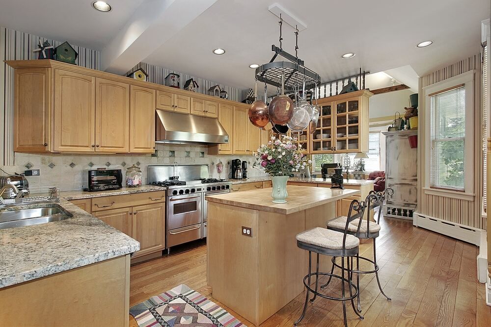 A Kitchen With Wooden Cabinets and Granite Counter Tops — Bruce Smith Cabinets in Bray Park, NSW