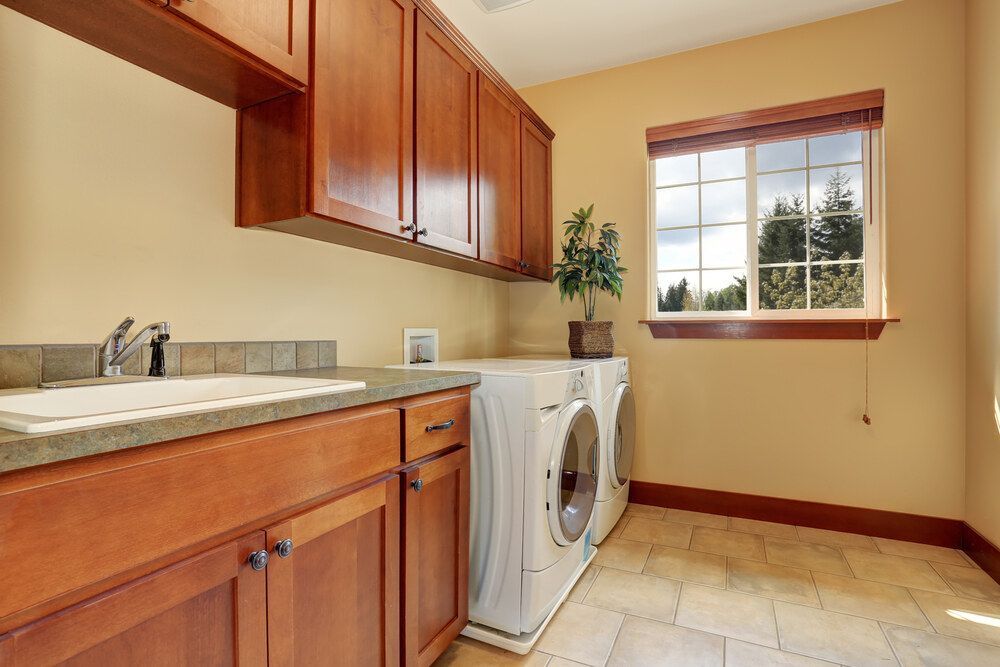 A Laundry Room With a Washer and Dryer and a Sink — Bruce Smith Cabinets in Byron Bay, NSW