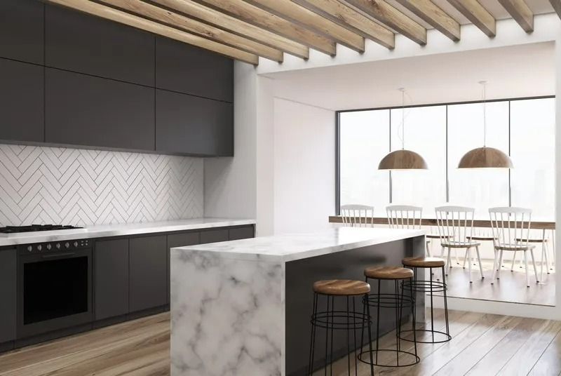 A Kitchen With a Marble Counter Top, Stools, and a Large Window — Bruce Smith Cabinets in Bray Park, NSW