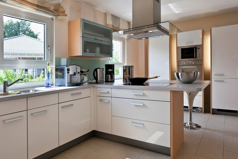 A Kitchen With White Cabinets and Stainless Steel Appliances — Bruce Smith Cabinets in Bray Park, NSW