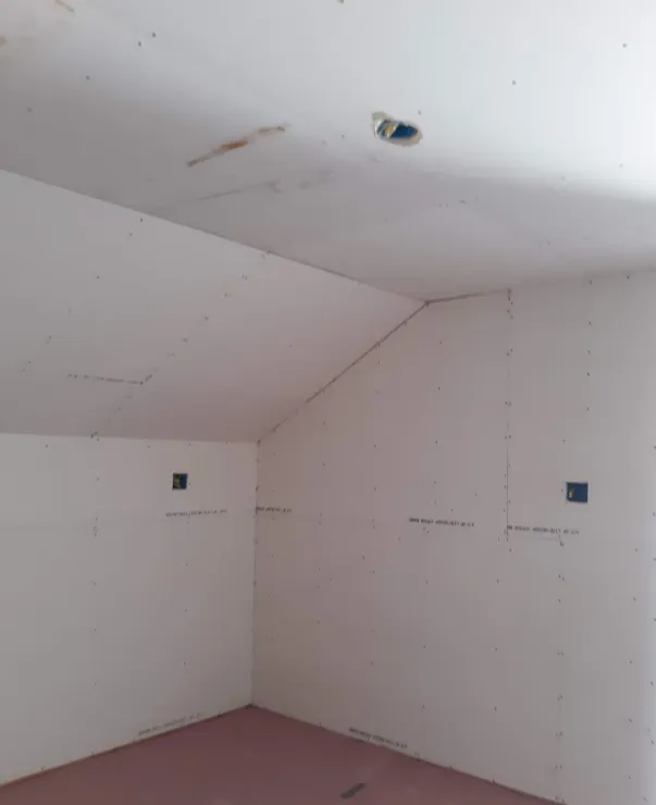 An empty room with white walls and a vaulted ceiling.
