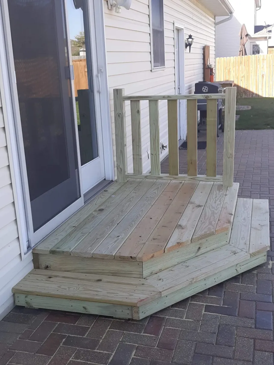 A wooden deck sits outside of a house