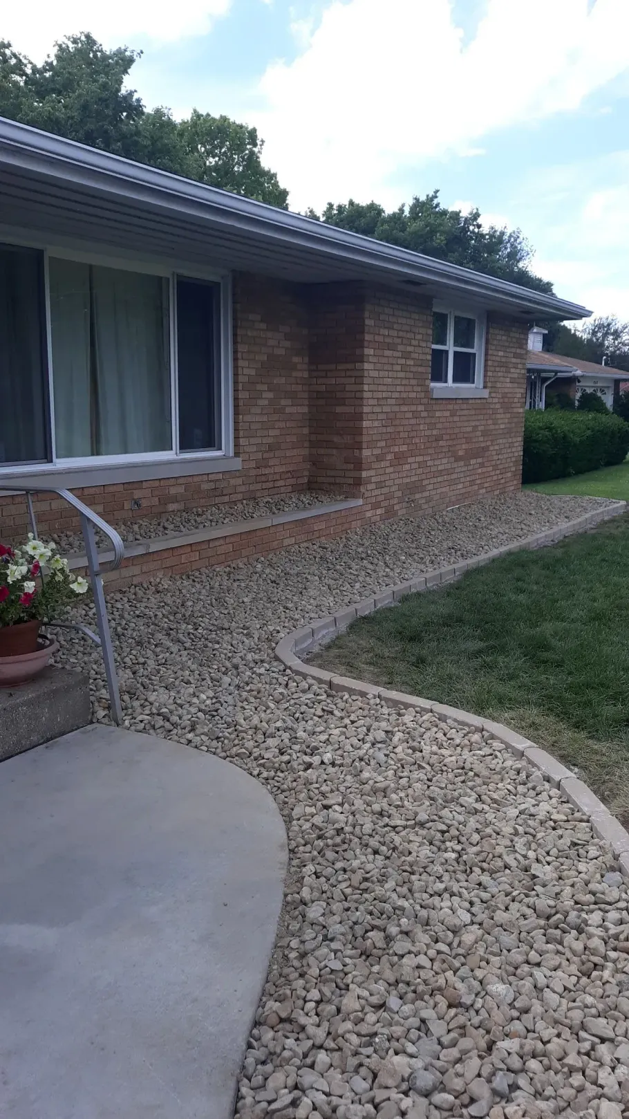 A brick house with a gravel walkway leading to it.
