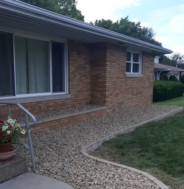 A brick house with a gravel walkway leading to it