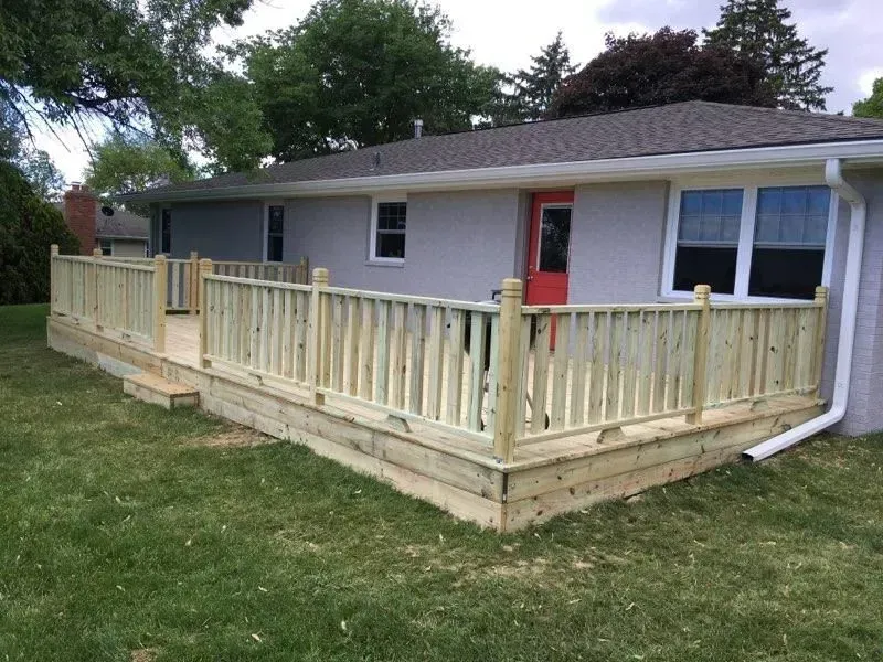 A house with a wooden deck in front of it.