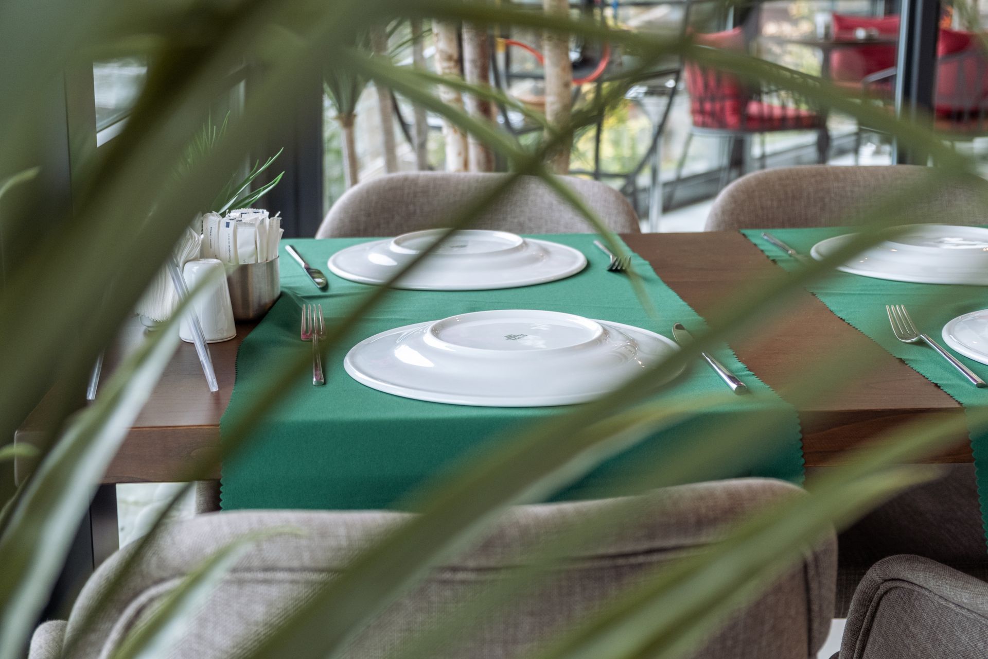 Üzerinde tabaklar ve gümüş eşyalar bulunan bir restoran masası.