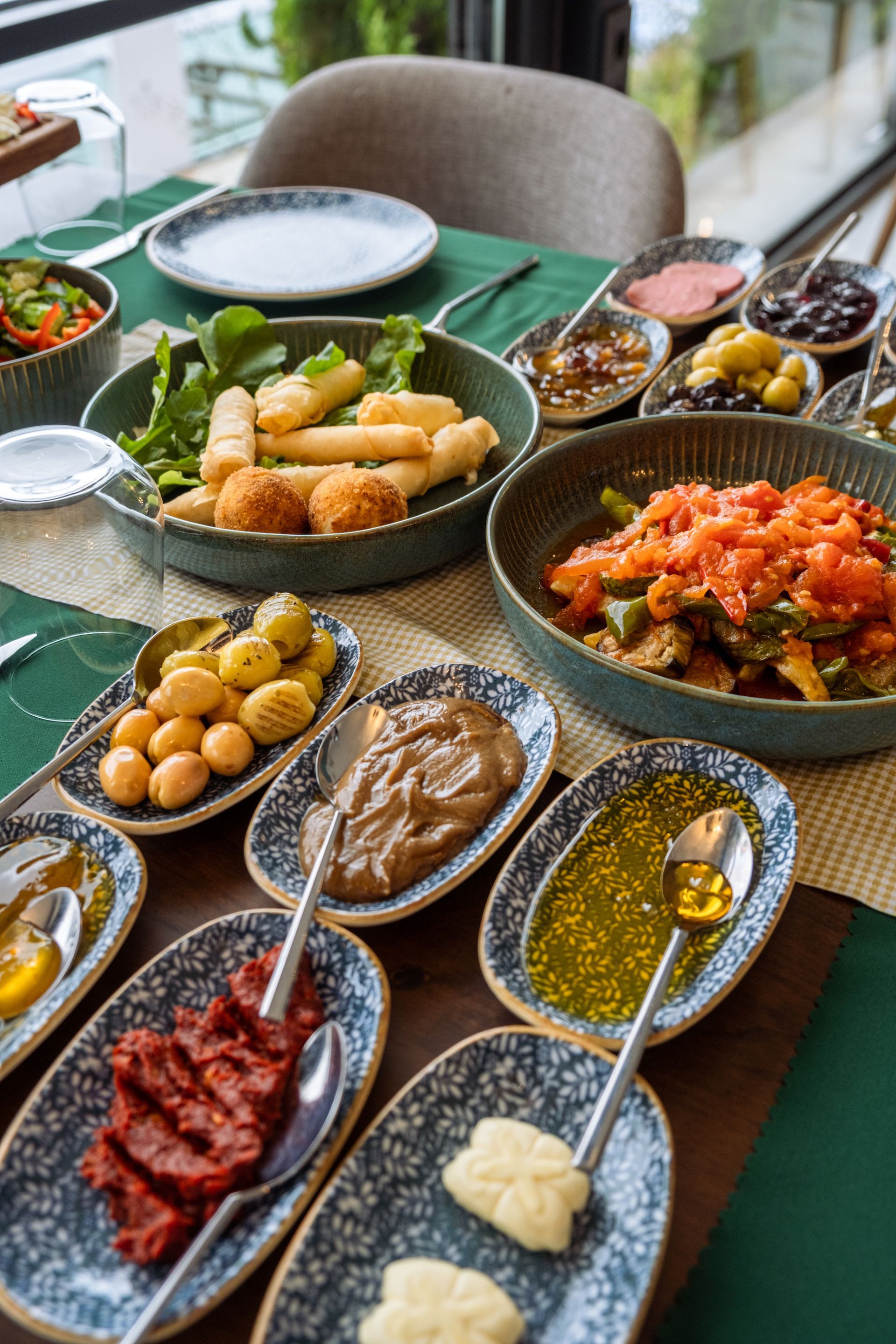 Üzeri yemek tabakları ve kaşıklarla dolu bir masa.