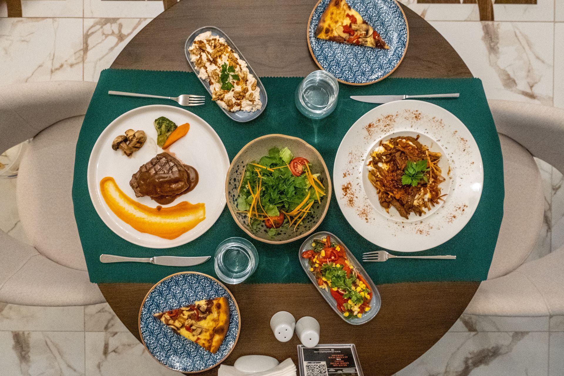 Üzeri yiyecek tabakları ve mutfak eşyalarıyla dolu bir masa.