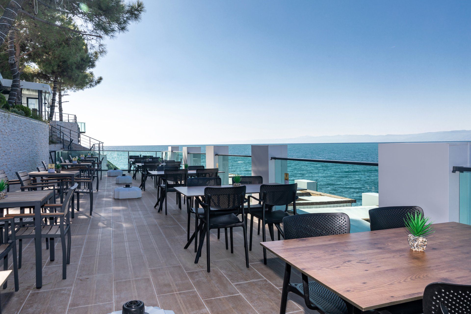 Okyanusa bakan masa ve sandalyelerin bulunduğu bir restoran