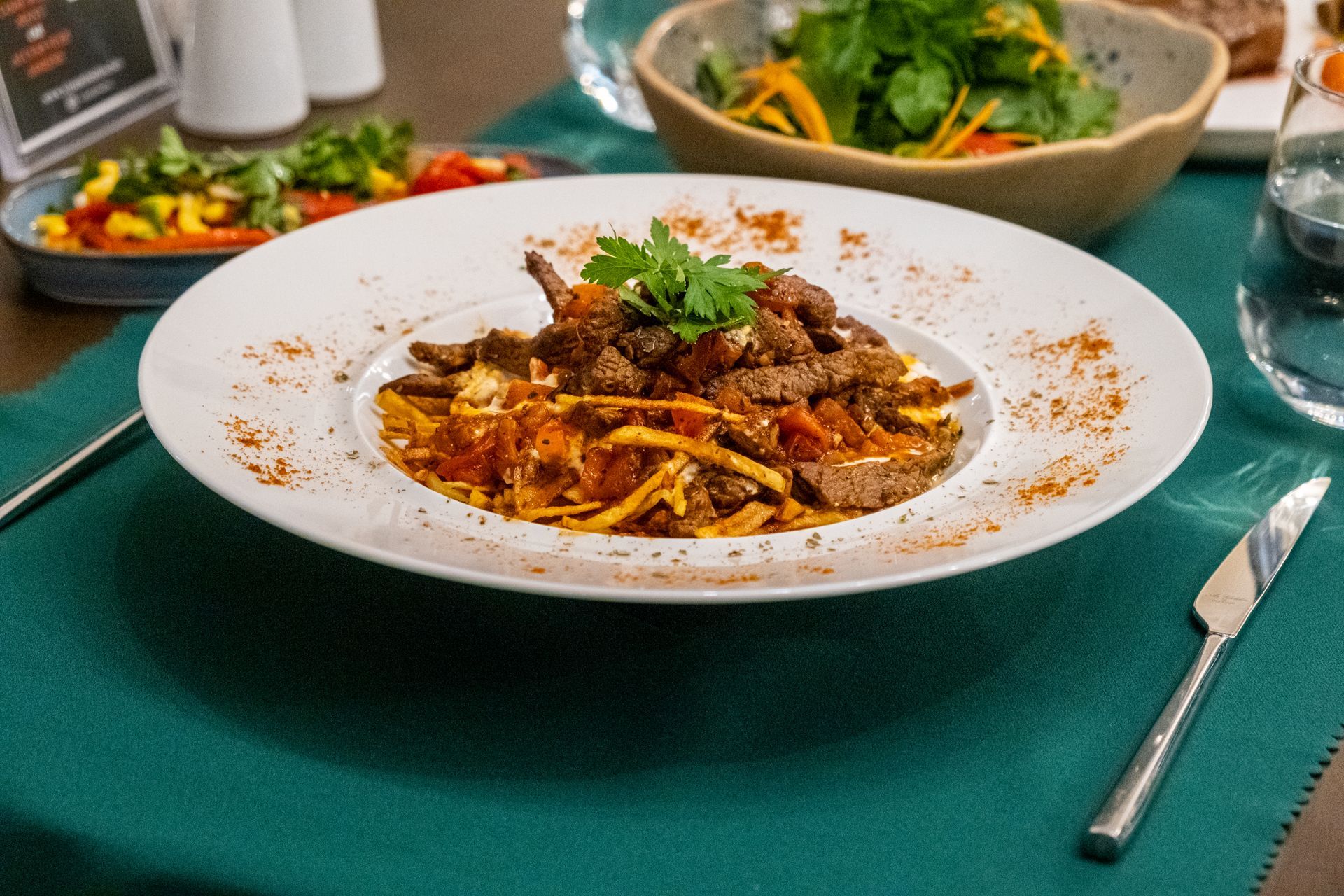 Masada et ve erişte bulunan bir tabak yemek.