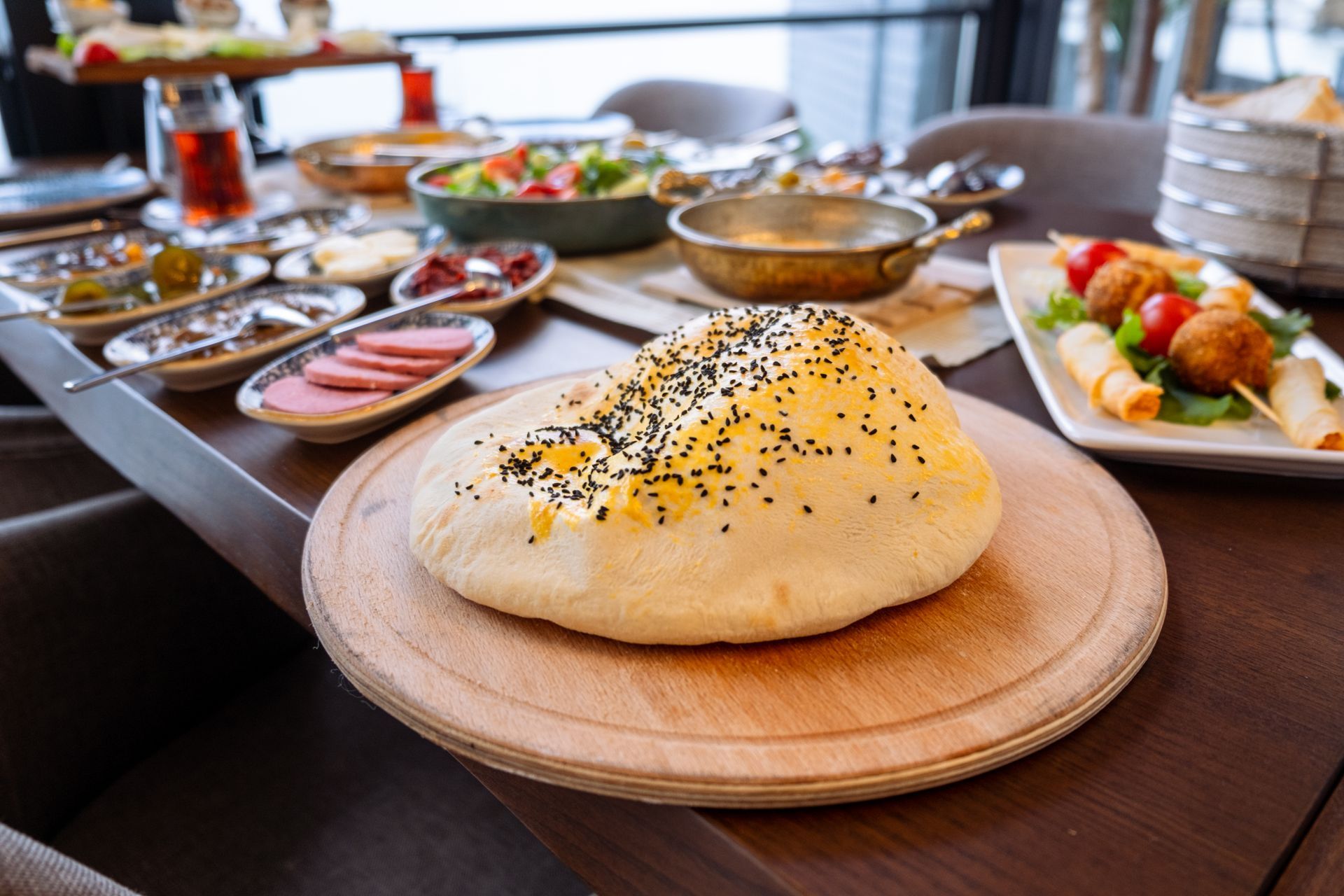 Bir somun ekmek masanın üzerindeki ahşap kesme tahtasının üzerinde duruyor.