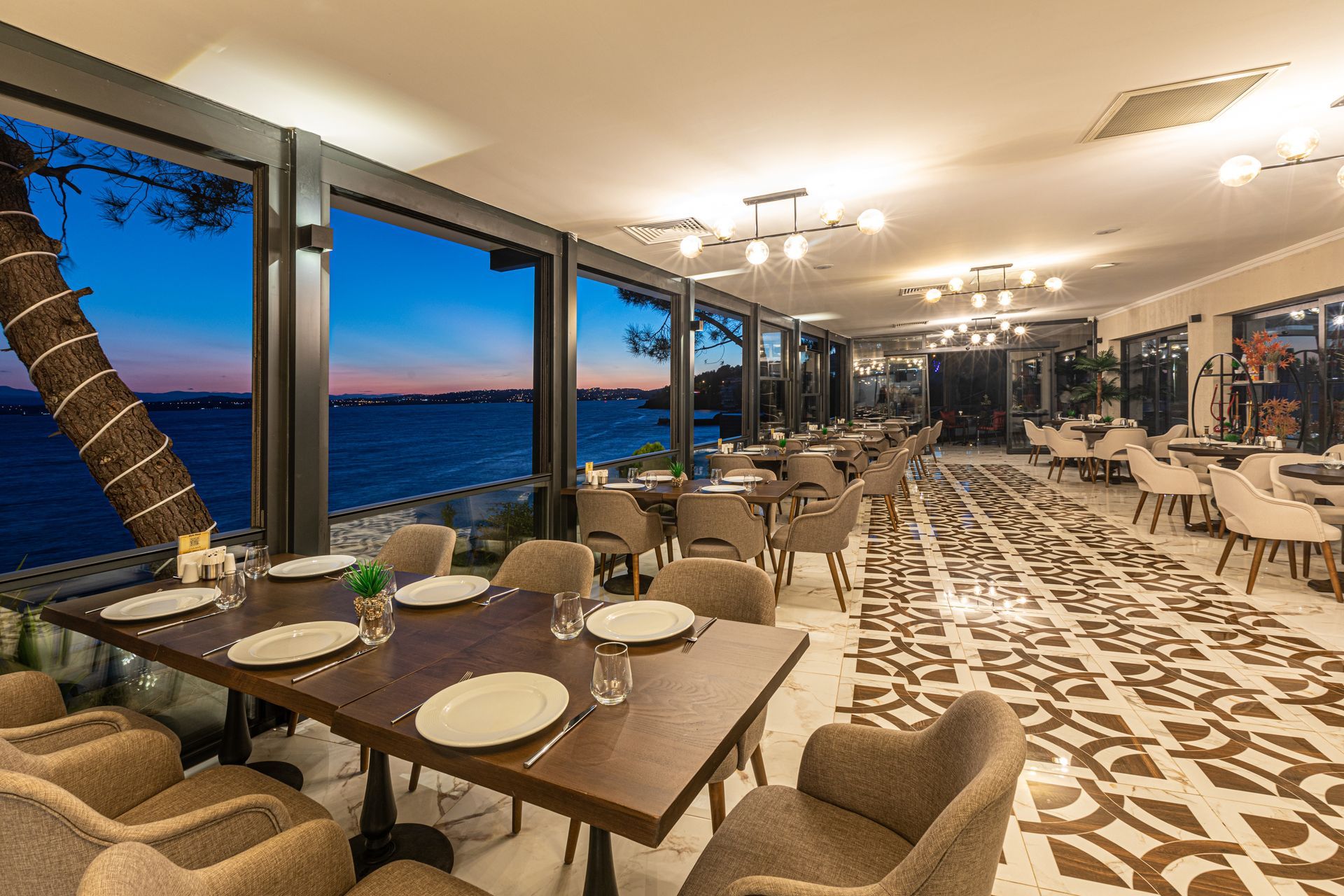 Masaları ve sandalyeleri olan, okyanus manzaralı bir restoran.