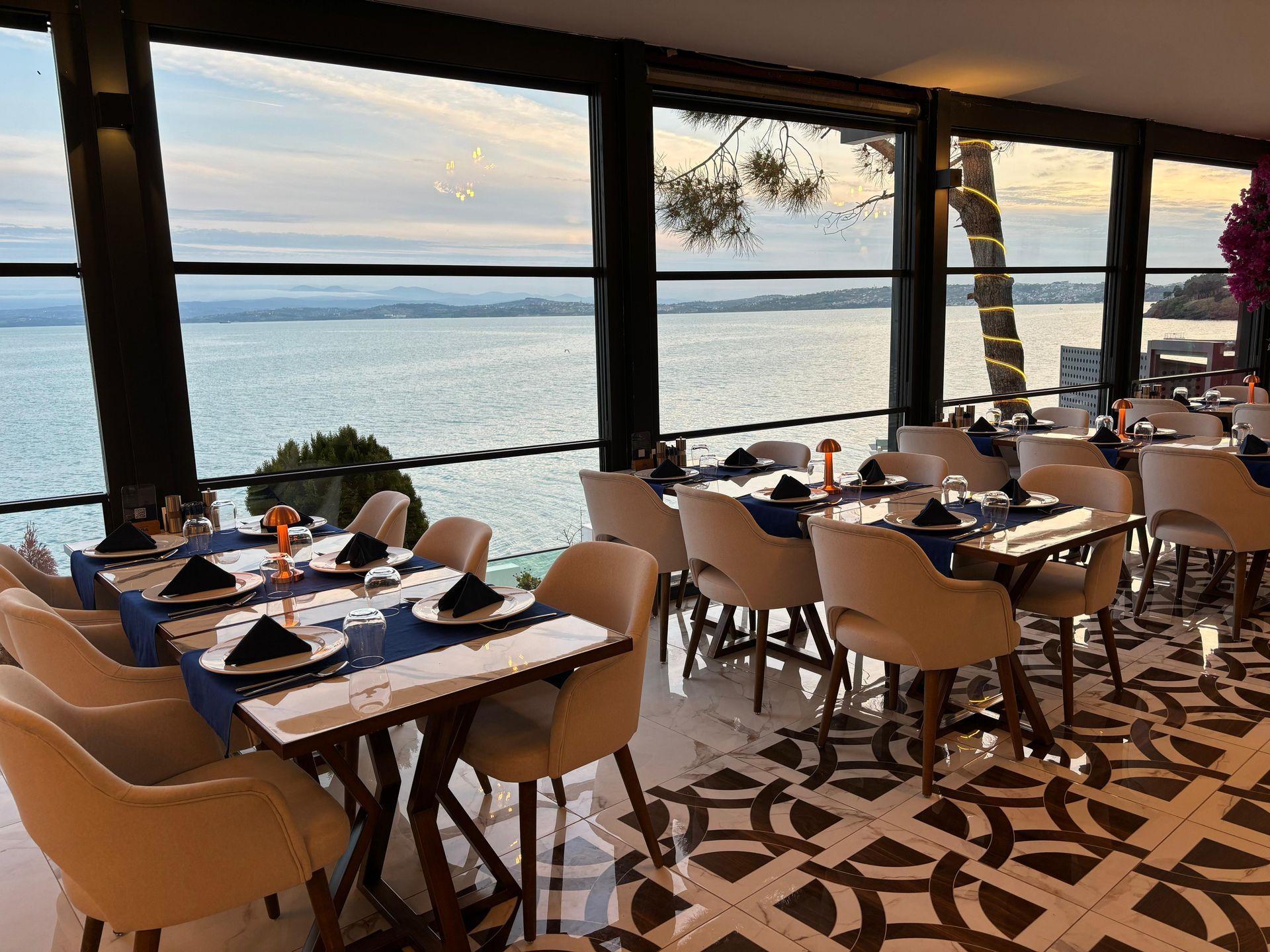 Okyanusa bakan, masaları ve sandalyeleri olan bir restoran.