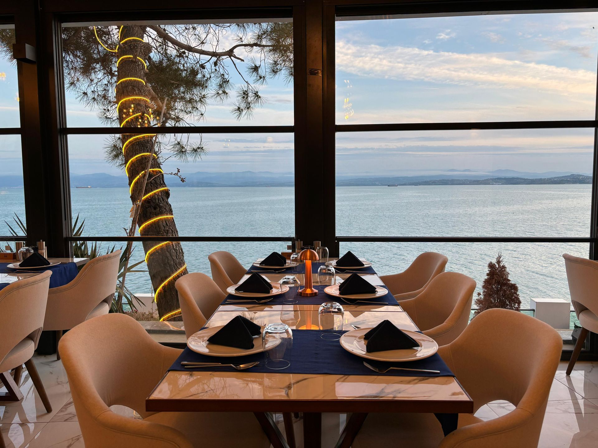Masaları ve sandalyeleri olan, okyanus manzaralı bir restoran.