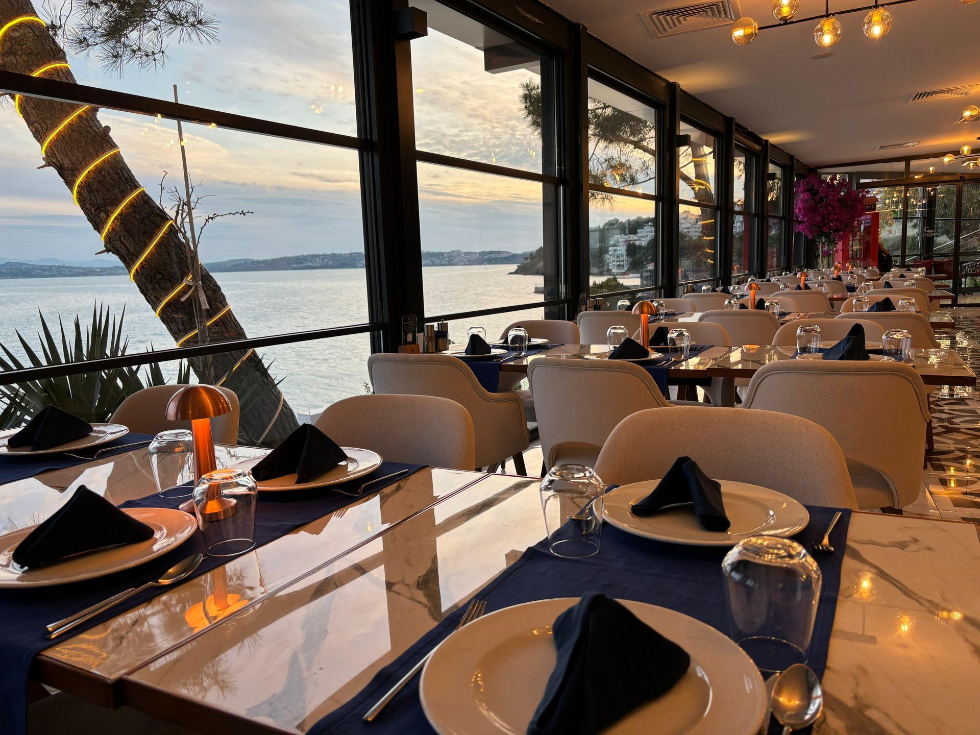 Okyanus manzaralı bir restoran masa ve sandalyelerle dolu.