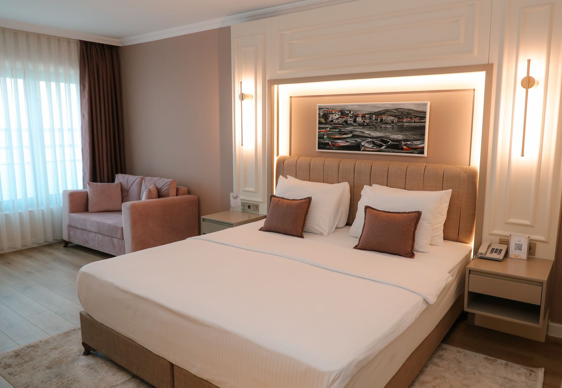 Büyük bir yatak ve kanepenin bulunduğu bir otel odası.