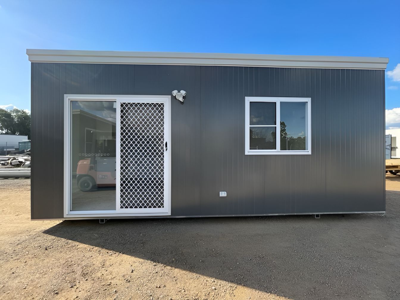 A Small House With a Sliding Glass Door and a Window — OSM Transportables In Dubbo, NSW