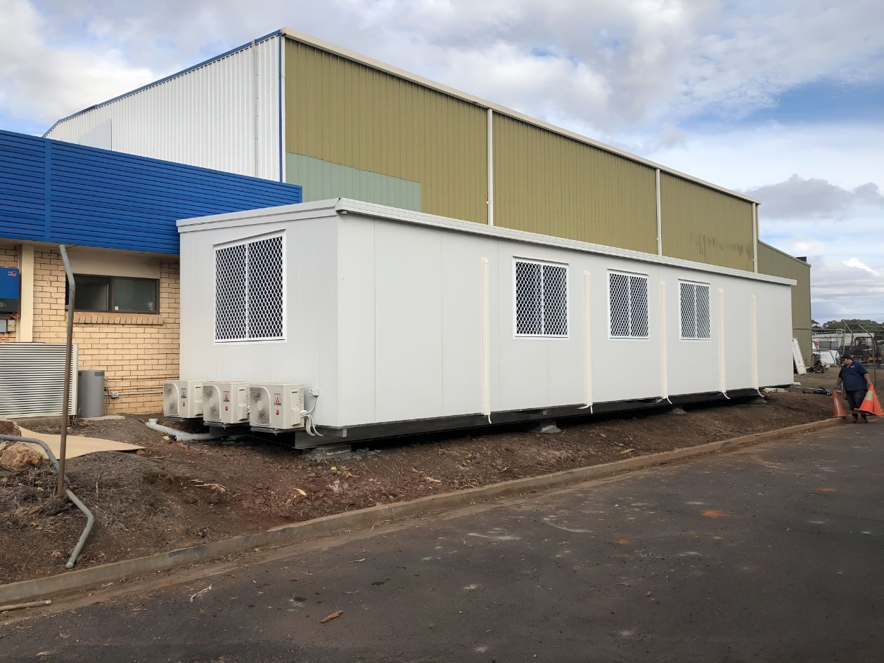 A Large White Container is Parked in Front of a Building — OSM Transportables In Parkes, NSW
