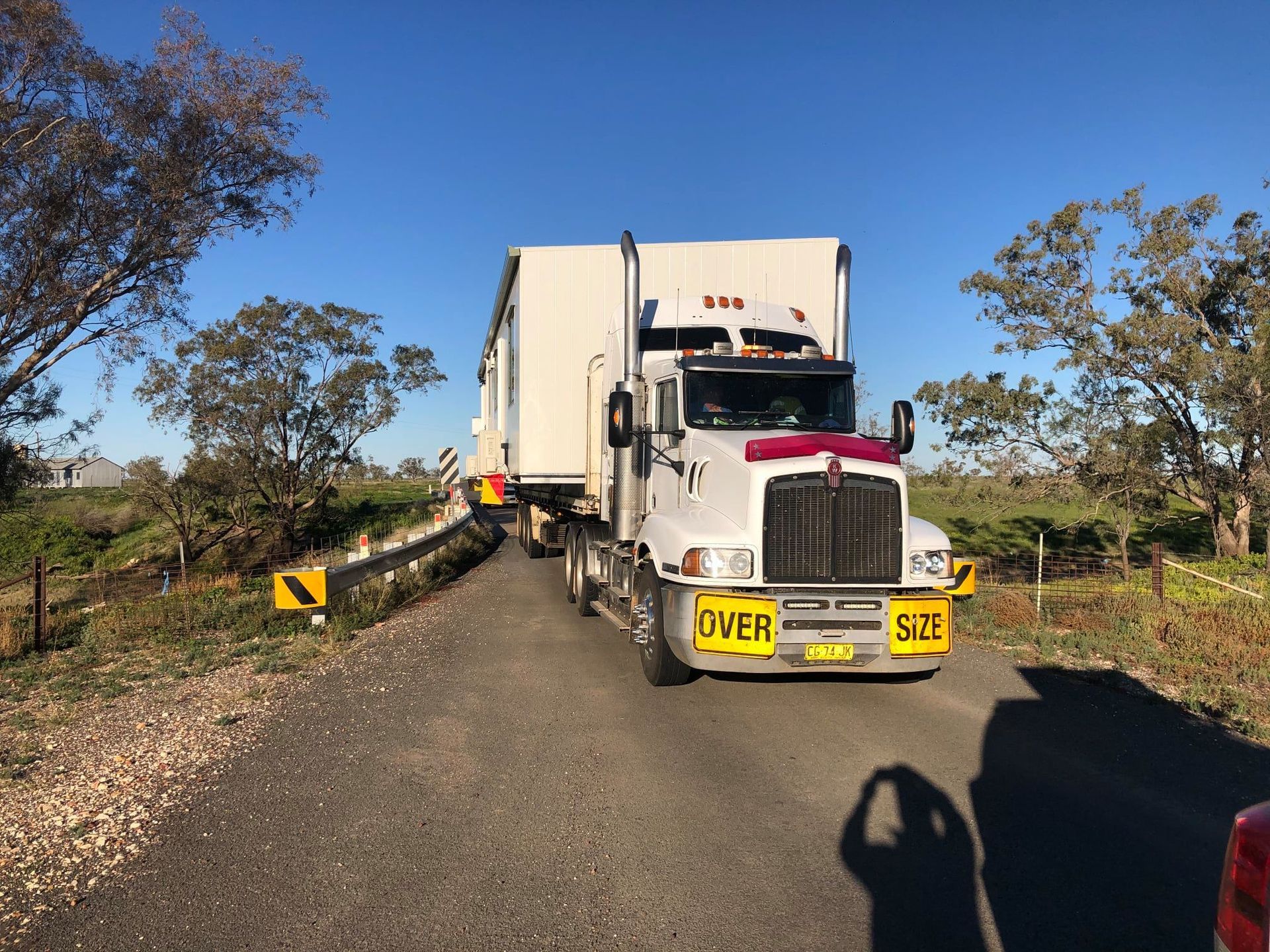 A White Kenworth Semi-truck Hauling a Large — OSM Transportables In Dubbo, NSW