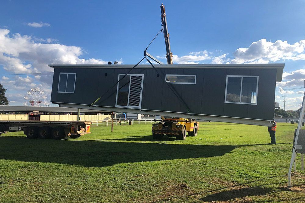 Two-bedroom House Being Lifted by a Crane Machine — OSM Transportables In Dubbo, NSW