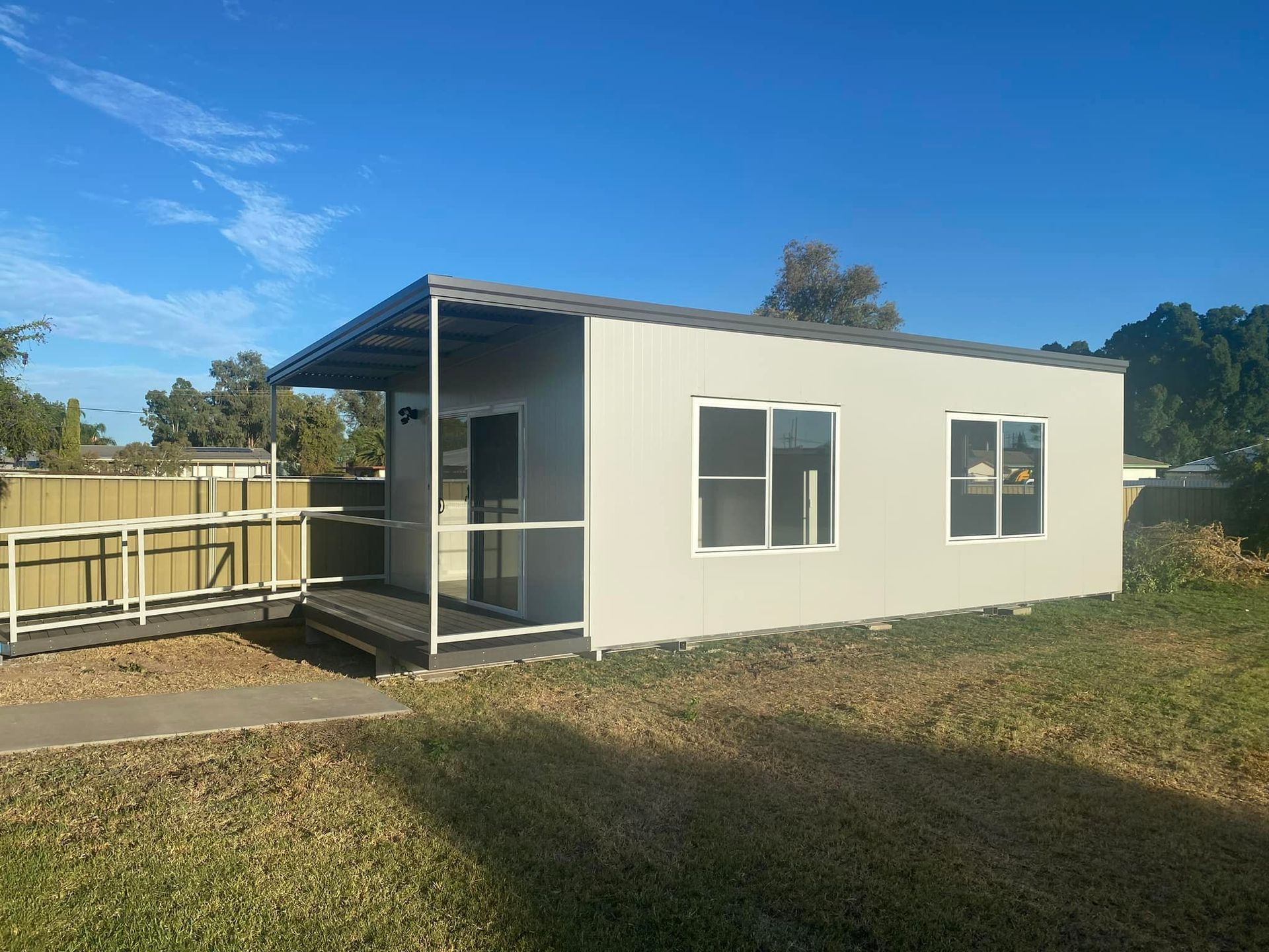A Light-colored, Rectangular Portable Cabin With a Small Covered Porch — OSM Transportables In Dubbo, NSW