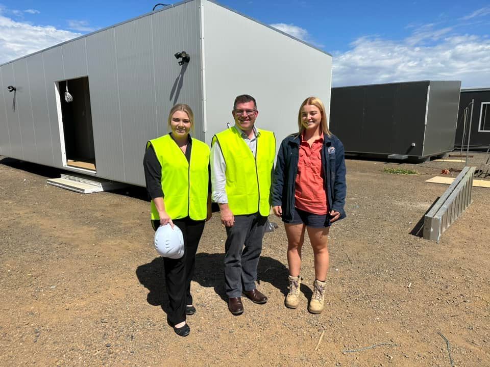 Three People Stand Outside Near a White Modular Building — OSM Transportables In Dubbo, NSW