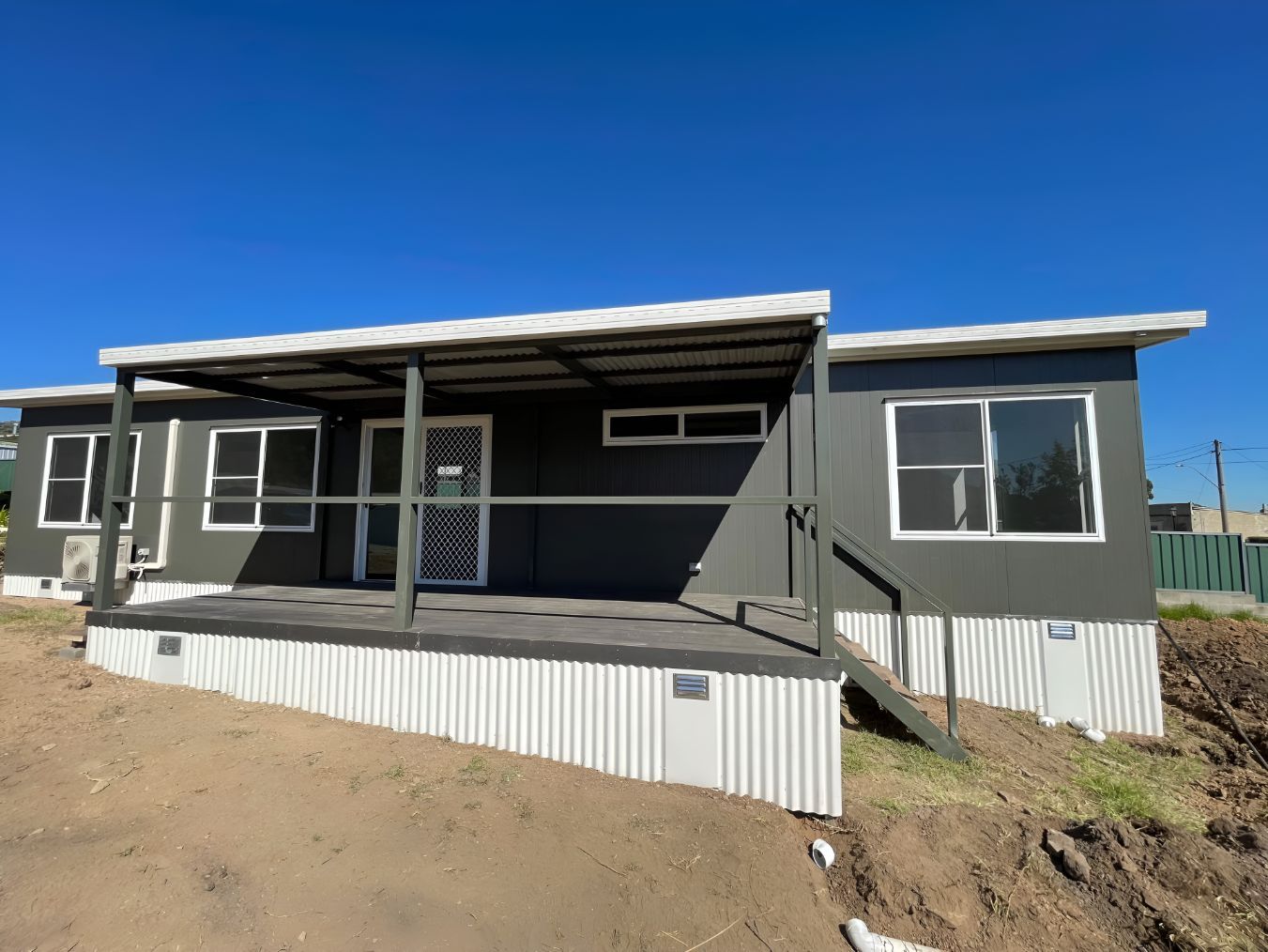 A sMall House With a Porch and Stairs is Sitting on Top of a Dirt Hill — OSM Transportables In Dubbo, NSW