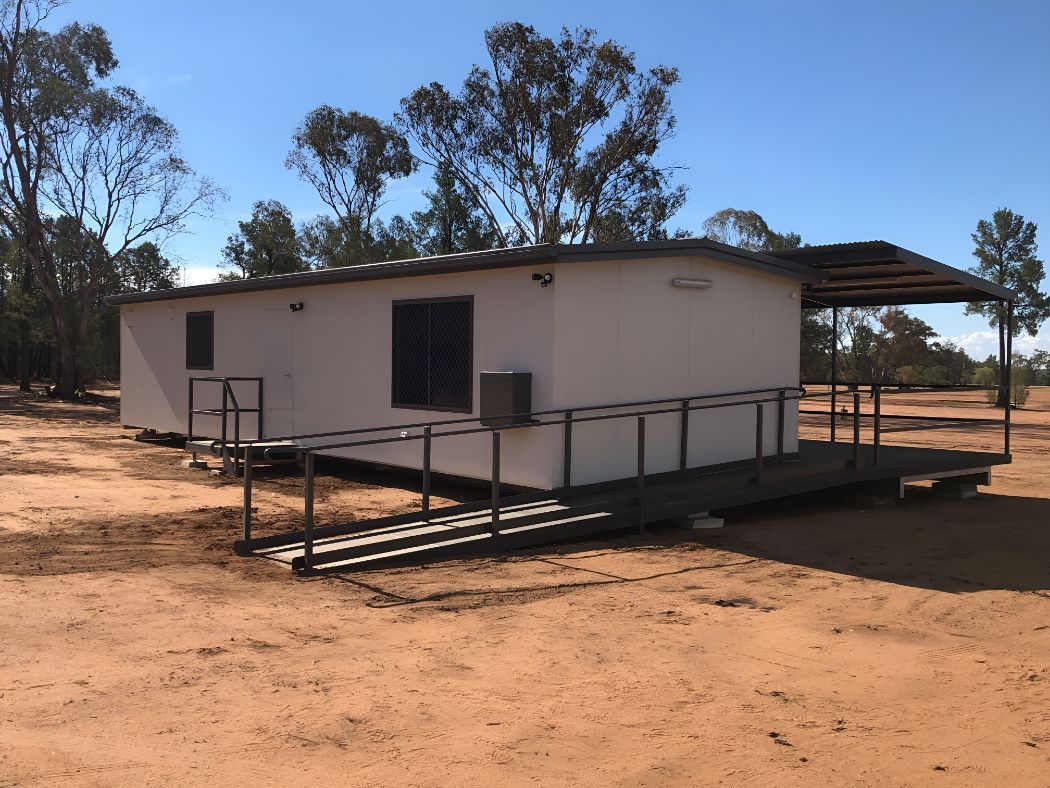 A Small White House With a Porch in the Middle of a Dirt Field — OSM Transportables In Cobar, NSW