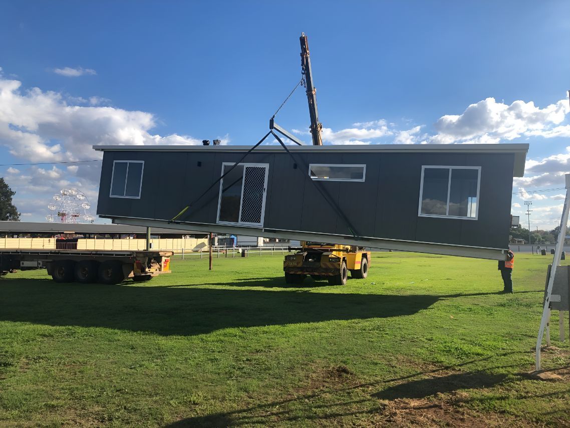 A Large House is Being Lifted by a Crane in a Field — OSM Transportables In Bourke, NSW