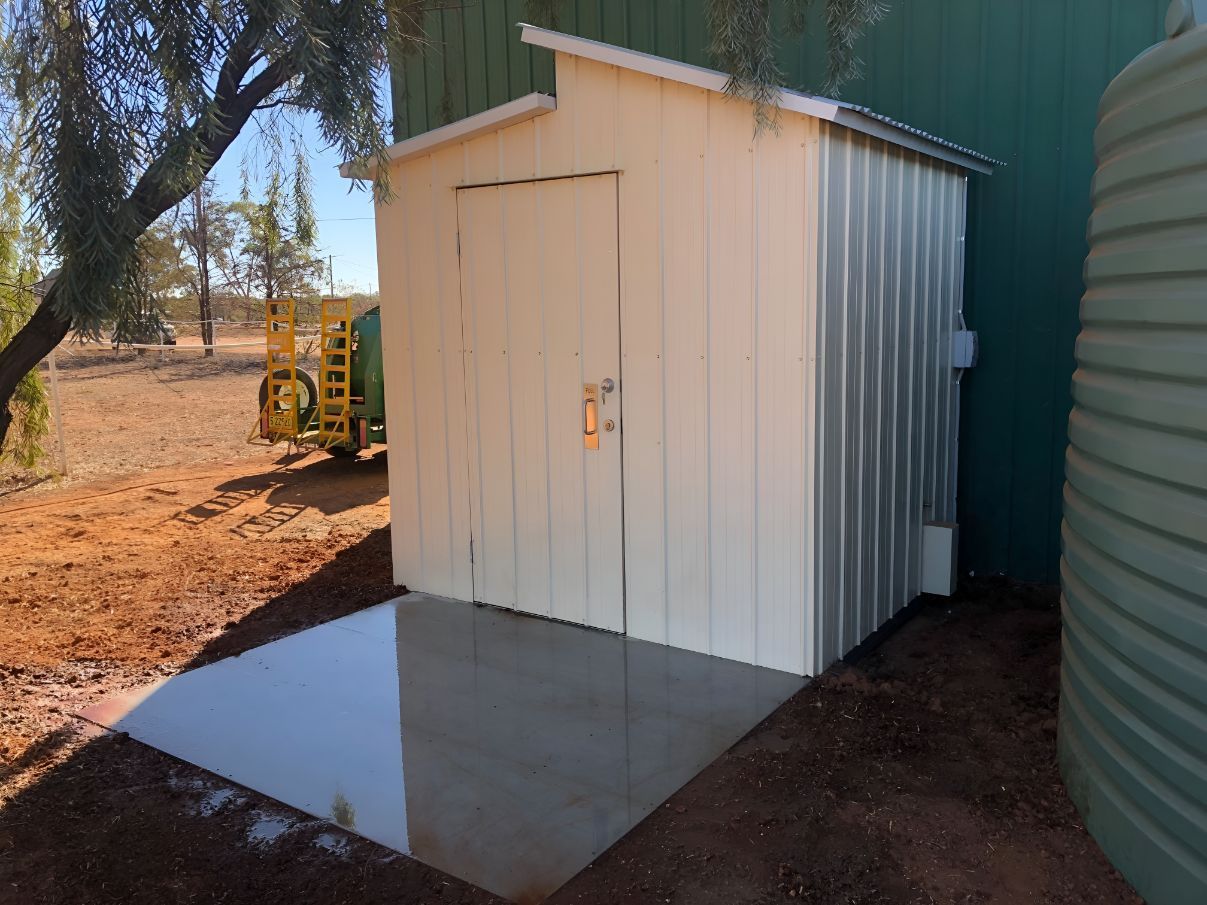 A White Shed With a Green Roof Sits Next to a Green Water Tank — OSM Transportables In Bourke, NSW