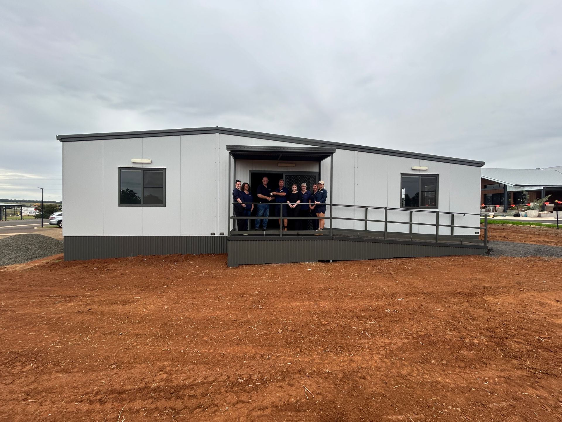 A Group Stands on the Ramp of a Light-colored — OSM Transportables In Dubbo, NSW