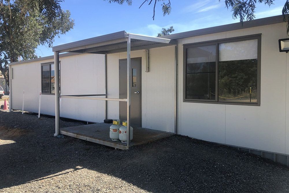 White Portable House With Gas Tanks in Its Porch — OSM Transportables In Dubbo, NSW