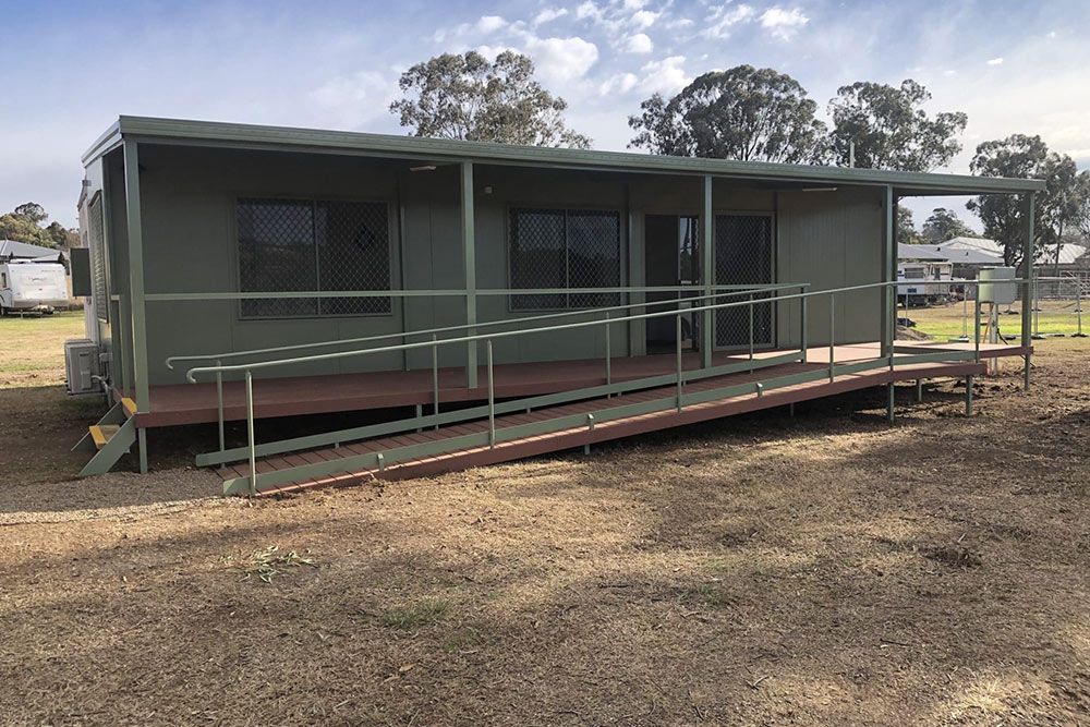 Dark Green Portable House With Long Red Staircase — OSM Transportables In Dubbo, NSW
