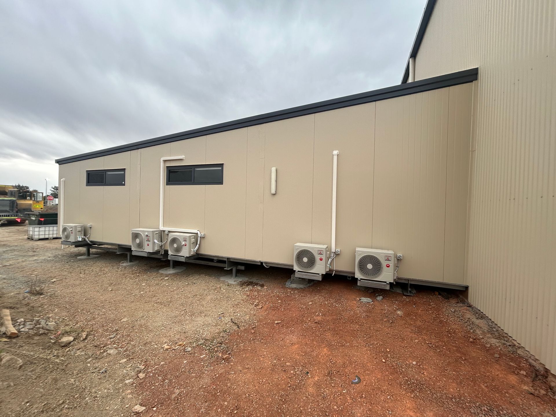 A Side View of a Beige, Modern Rectangular Building Featuring Two Windows — OSM Transportables In Dubbo, NSW