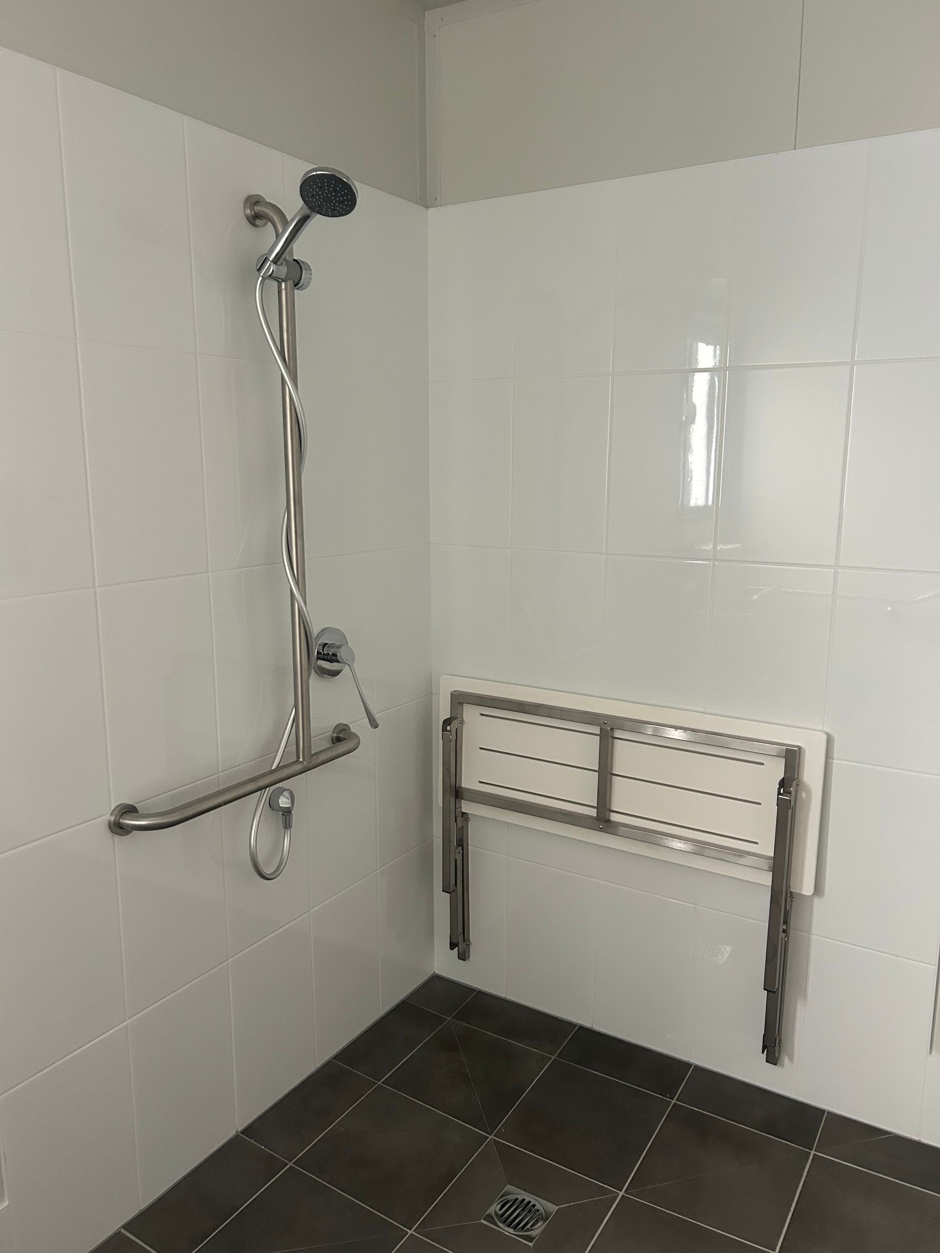 A Shower Stall Featuring a White Wall-mounted Folding Seat — OSM Transportables In Dubbo, NSW