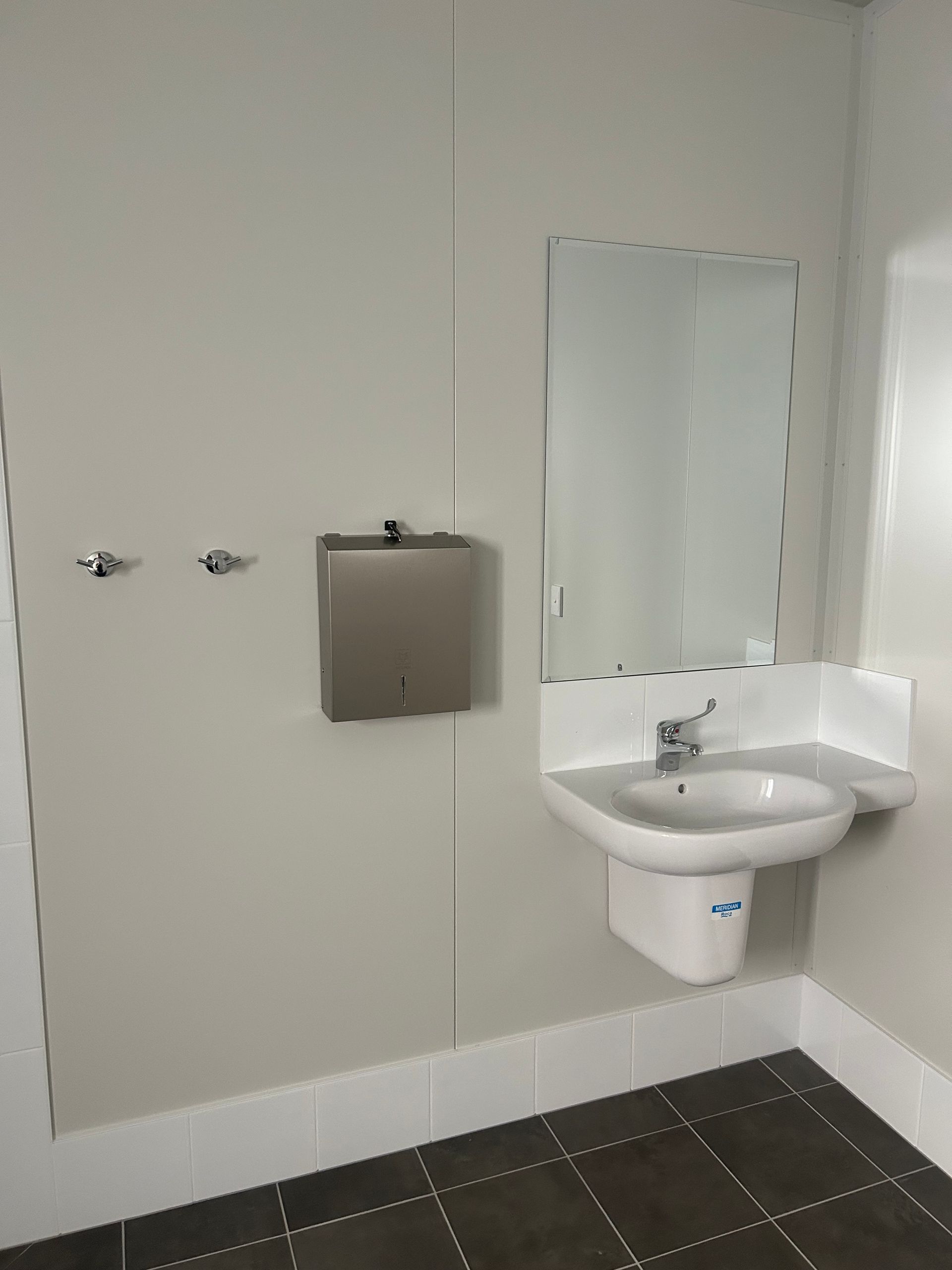 A Clean Public Restroom Features a White Wall-mounted Sink With a Mirror Above It — OSM Transportables In Dubbo, NSW