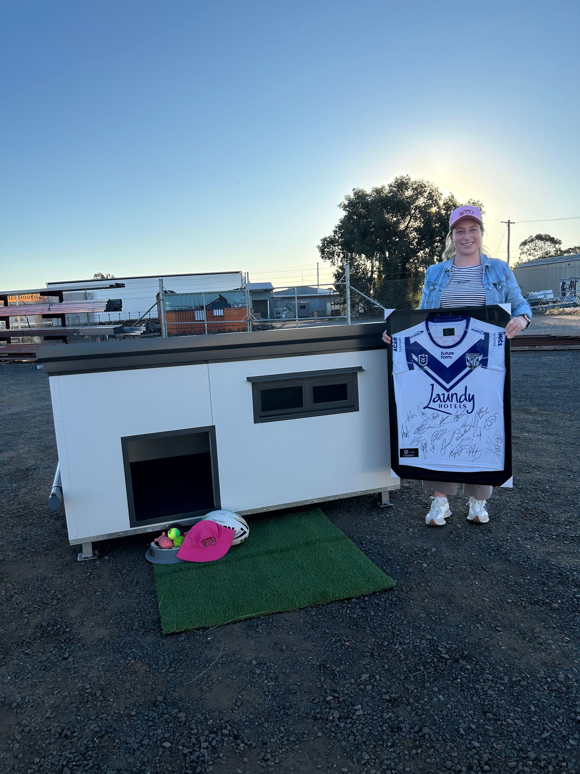 A Person Holds a Signed White and Blue Sports Jersey — OSM Transportables In Dubbo, NSW