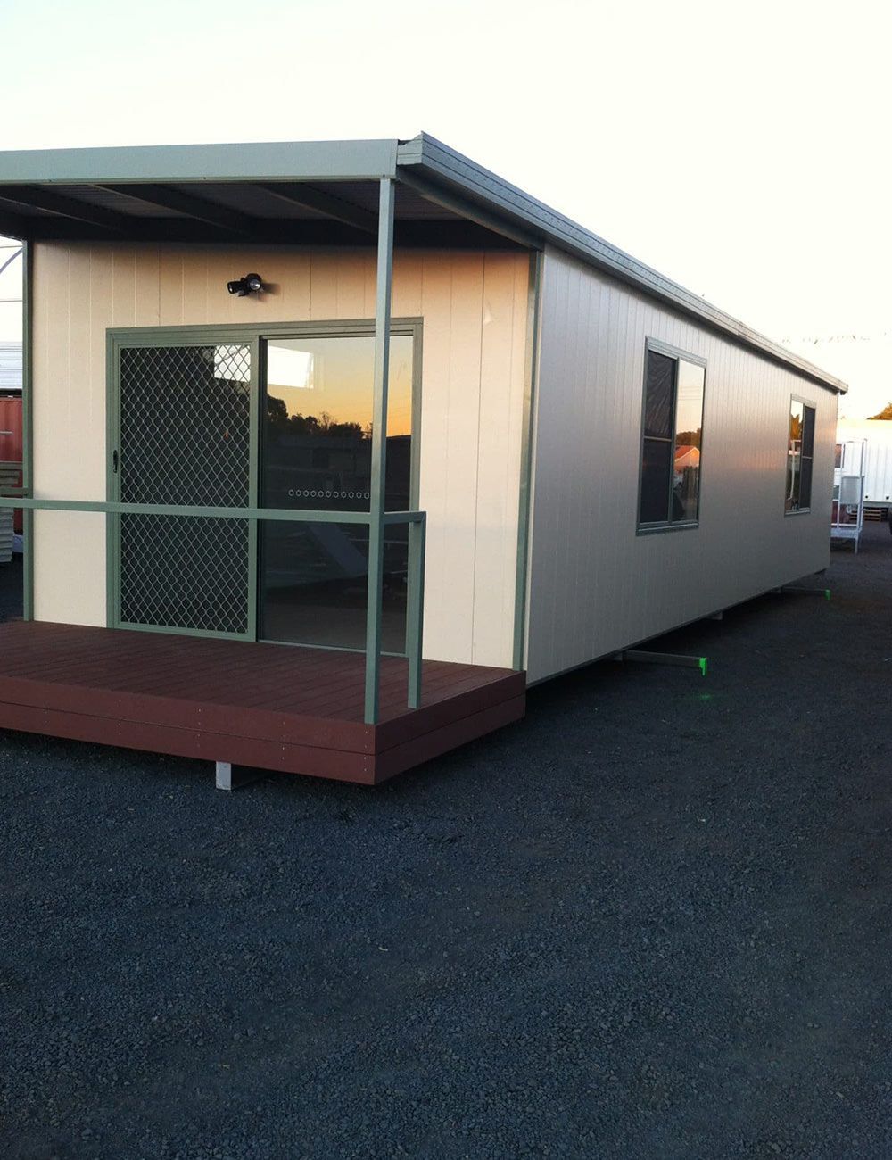 Front View of Portable House With Green Fence and Green Sliding Door — OSM Transportables In Dubbo, NSW