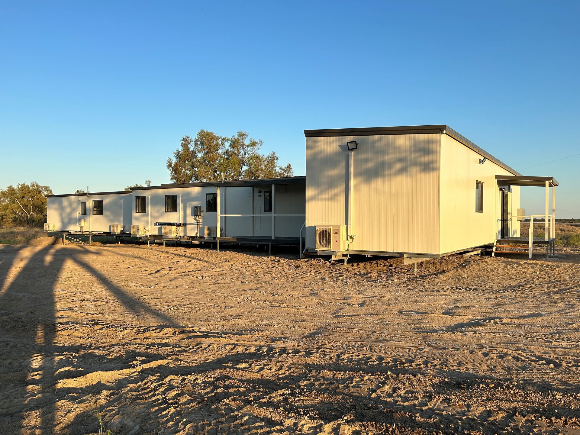 A Long, White Modular Building Sits on a Dry — OSM Transportables In Dubbo, NSW